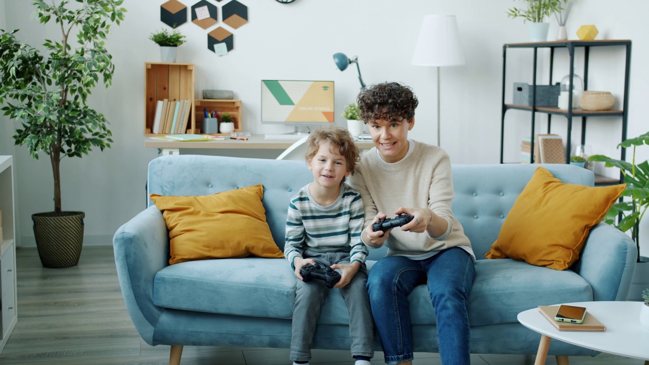 画像的孩子玩电子游戏与父母使用操纵杆有乐趣在家里视频素材