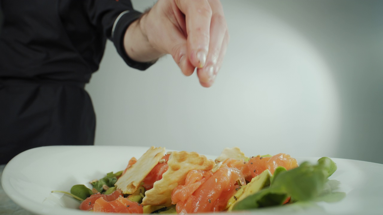 近距离拍摄的一个男人的手厨师，准备海鲜和蔬菜沙拉视频下载