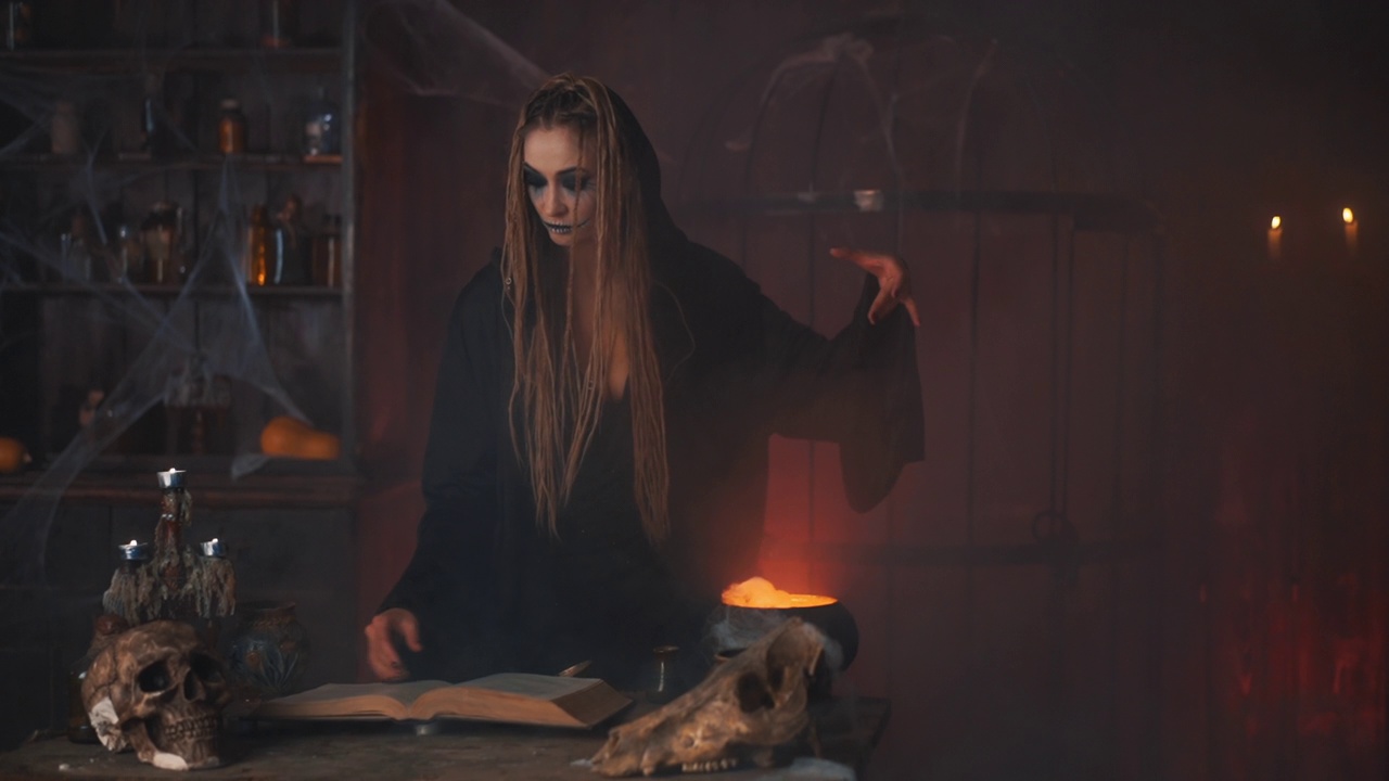 万圣节前夕，巫婆用魔法书和坩埚准备毒药或爱情药水视频素材