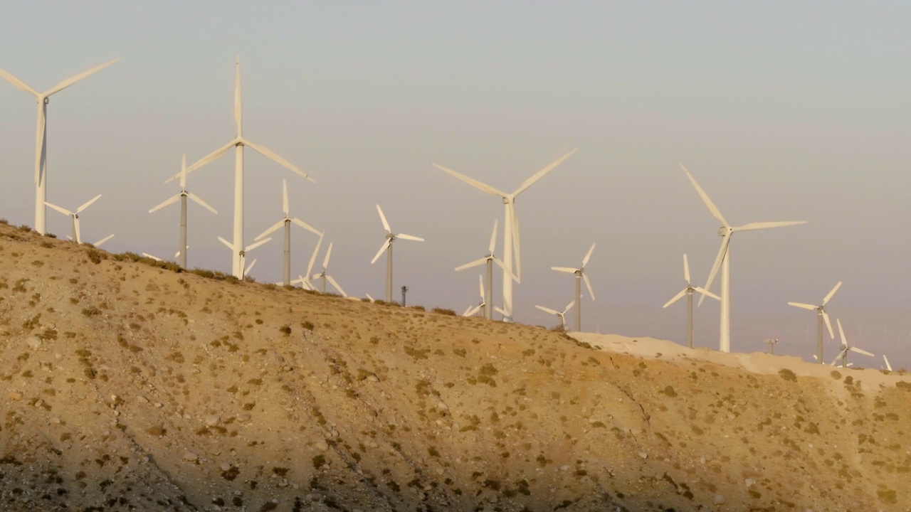 空中拍摄的风车旋转的沙漠景观，背景是晴朗的天空-棕榈泉，加利福尼亚视频素材
