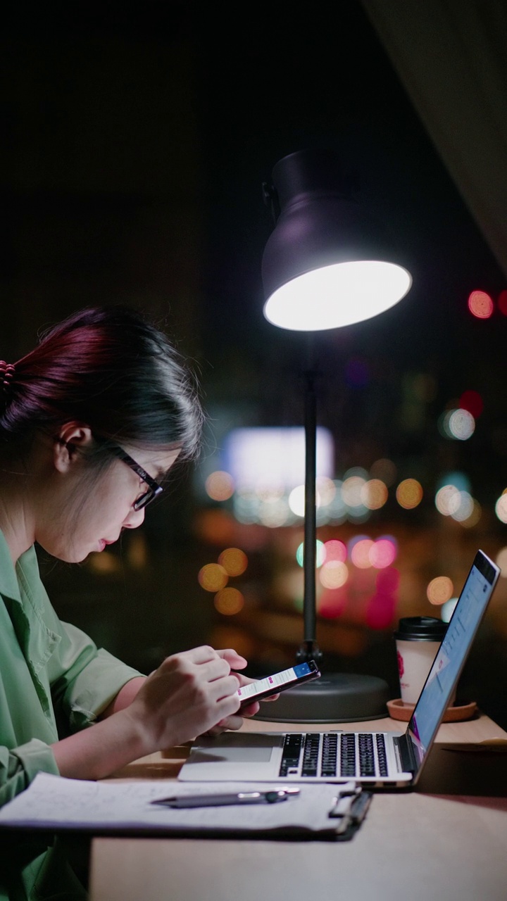 一个女人在晚上用笔记本电脑学习电子学习视频下载