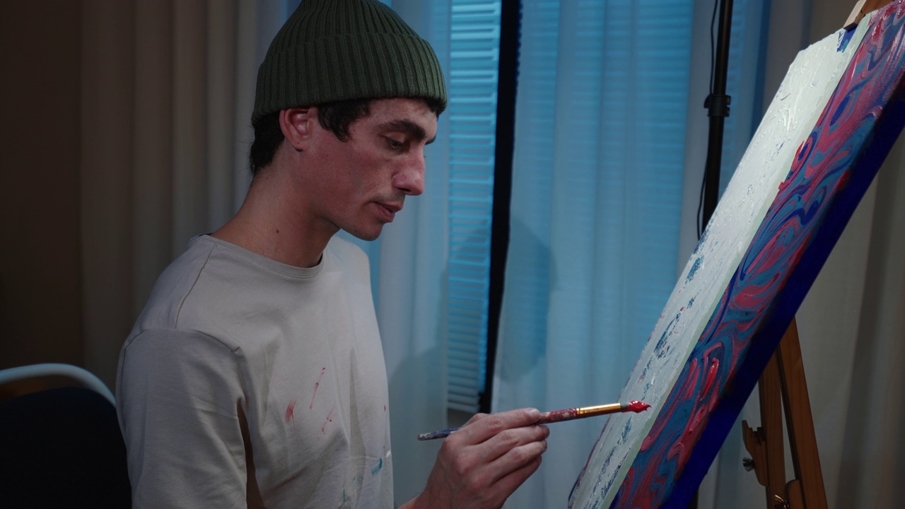 才华横溢的男性艺术家在画布上用画笔进行最后的润色。视频素材