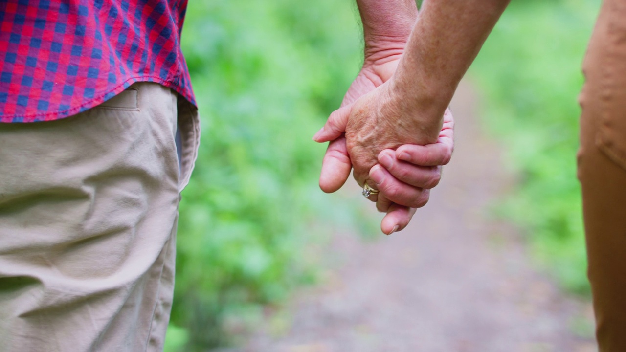 亲密的爱情成熟的夫妇手牵着手走在乡间的小路上视频下载