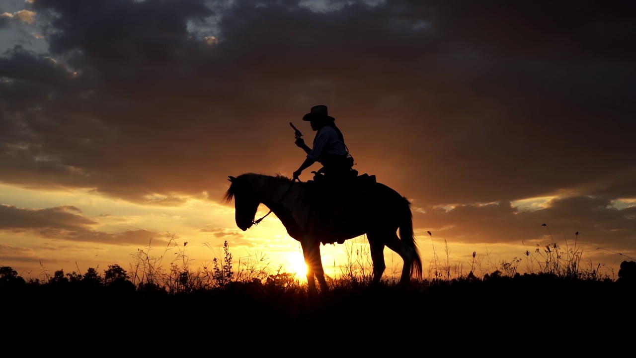 骑马和拿枪看日落的牛仔视频素材