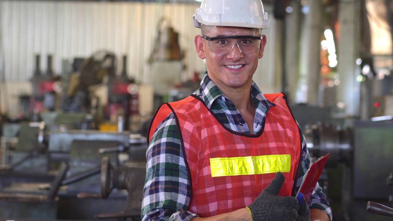 在工业工厂里，白人工程师工头双臂抱着记事本微笑着对着镜头视频素材