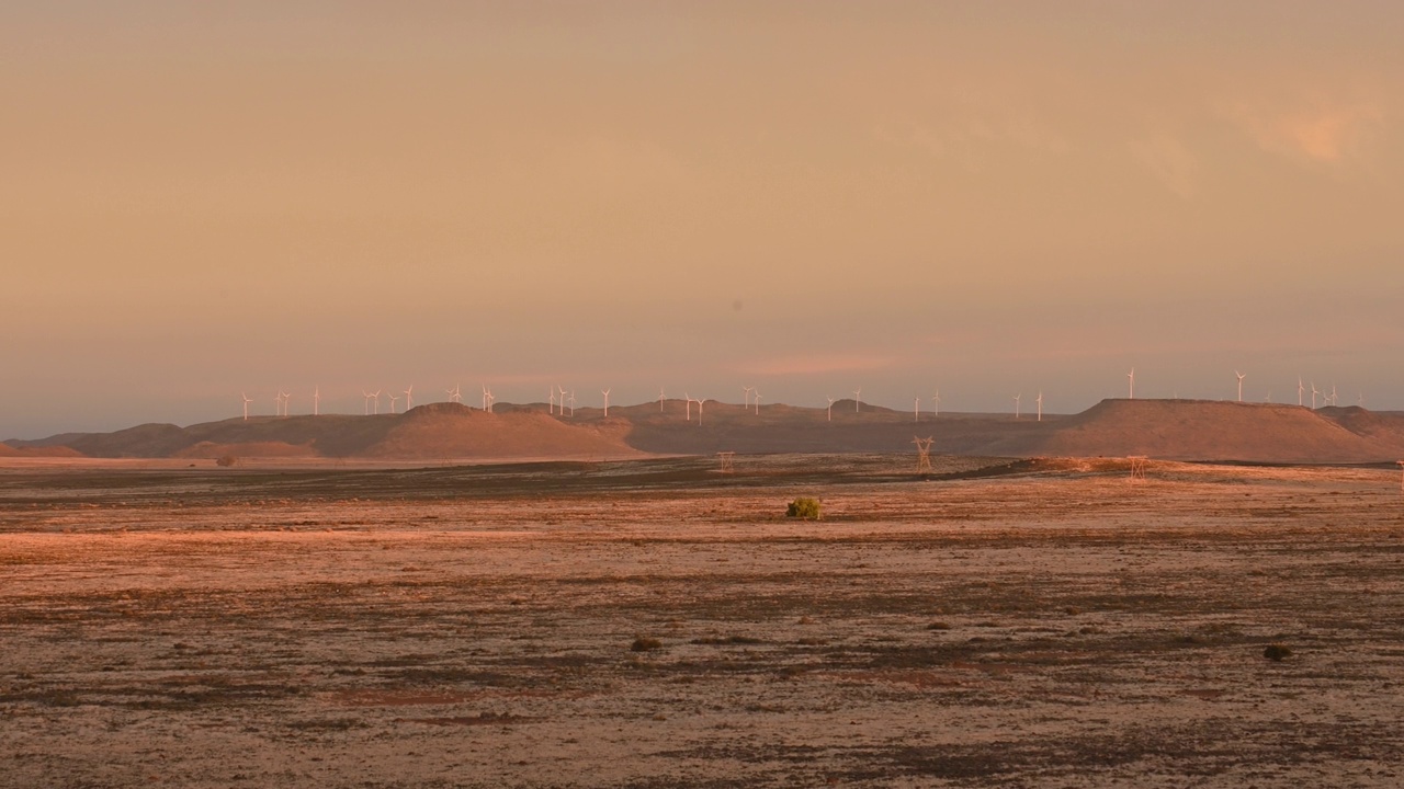 日落时分的大卡鲁干旱山丘上的风力涡轮机农场视频下载