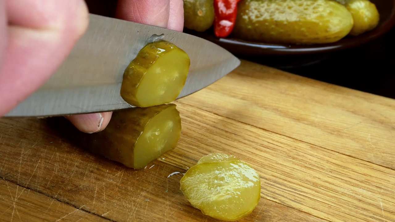 腌黄瓜用快刀在厨房木板上切。视频素材