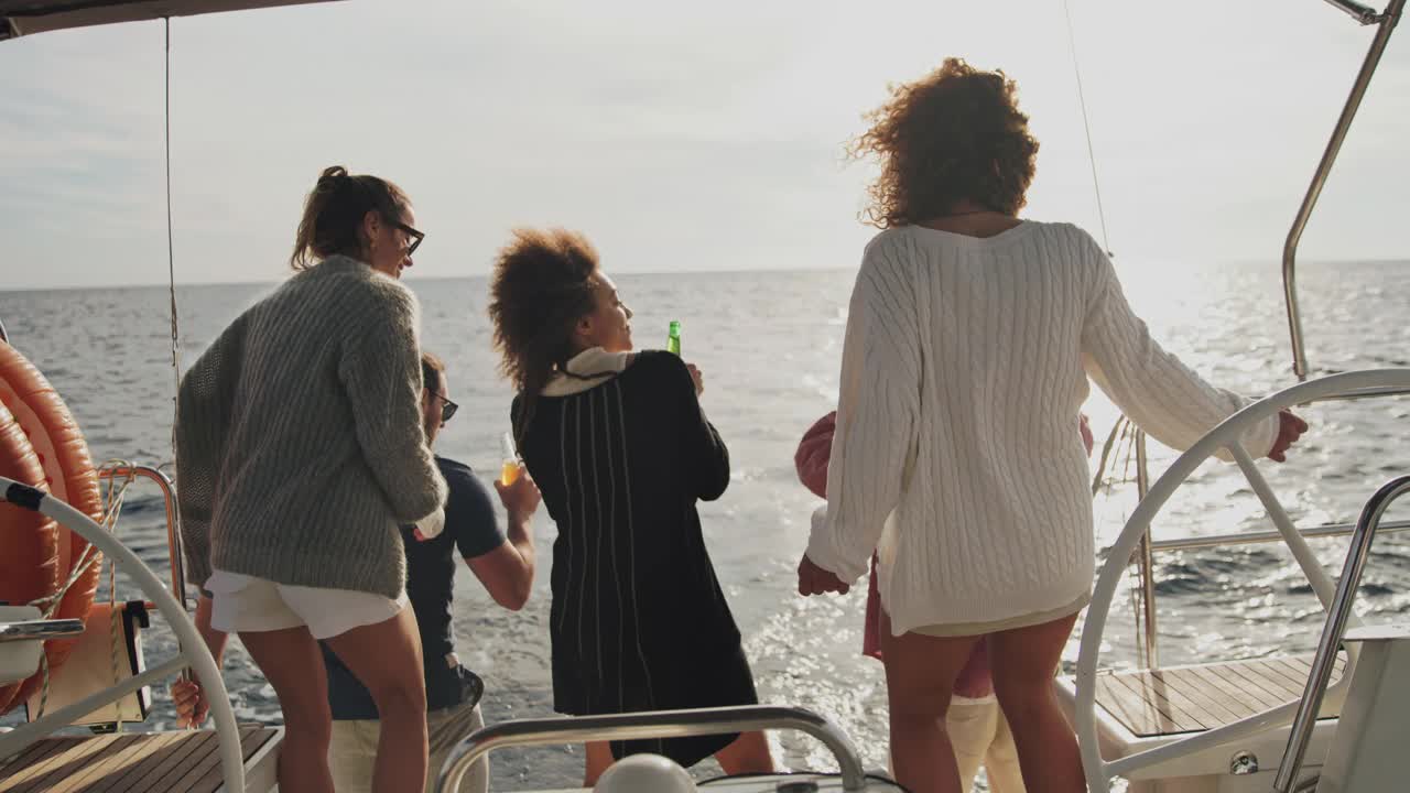 日落时分，一群朋友在船上的甲板上愉快地跳舞视频素材