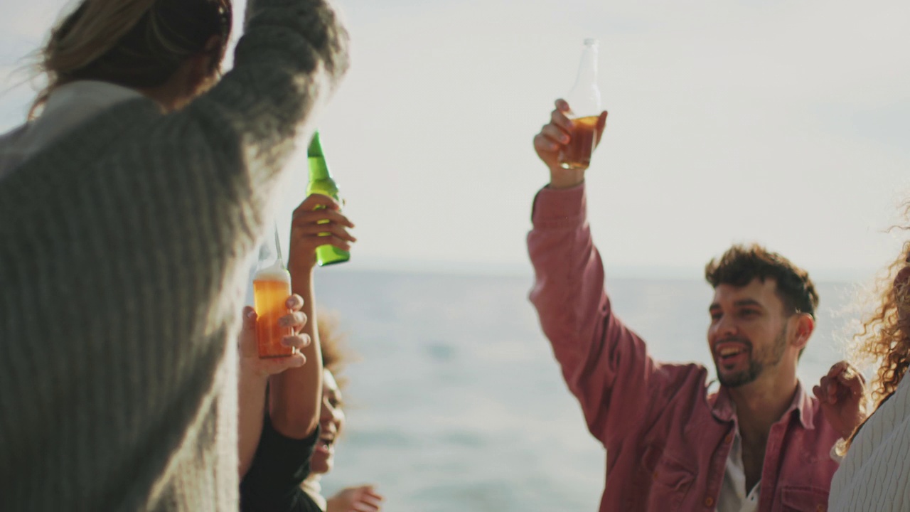 日落时分，朋友们在船上用酒瓶举杯祝酒视频素材