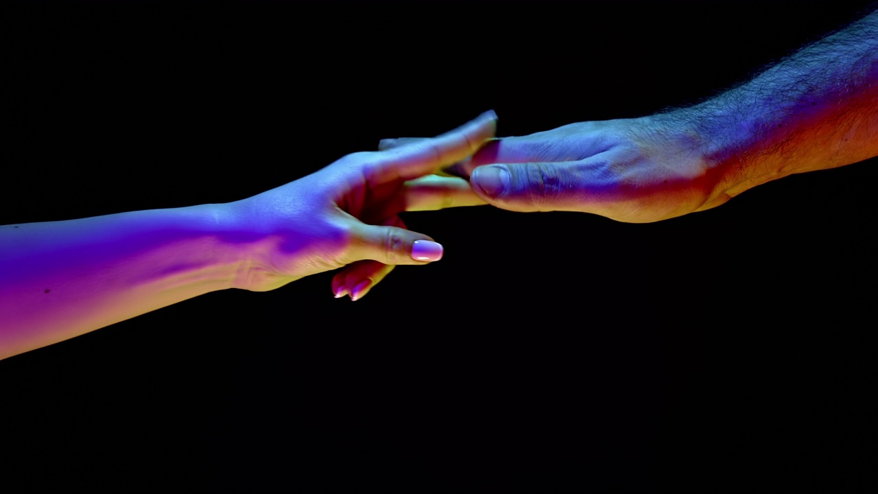 情侣玩石头剪刀布，在霓虹灯下的黑色背景下的手游戏。两只手——男性和女性选择谁是第一，解决争端，做决定视频下载