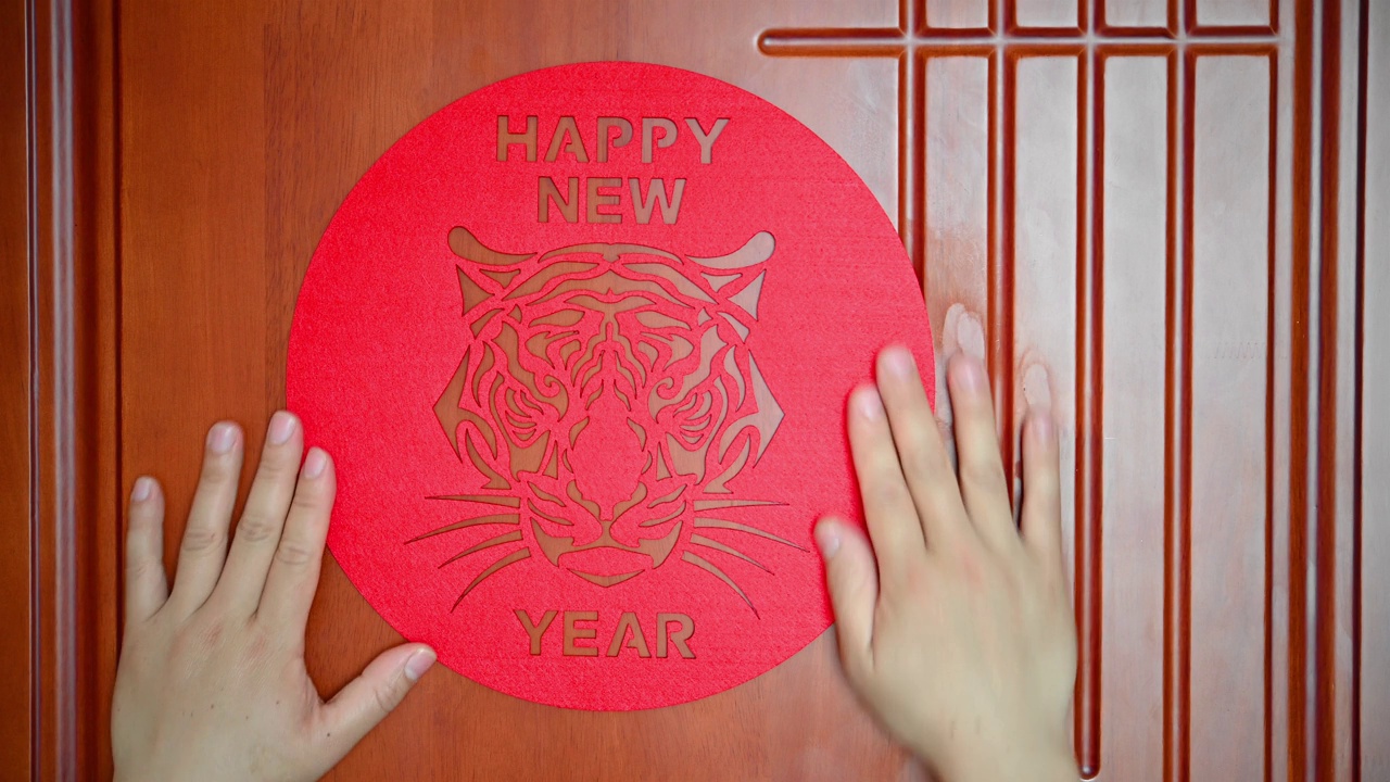 将2022年虎年的吉祥物贴在门上，寓意虎年快乐视频下载