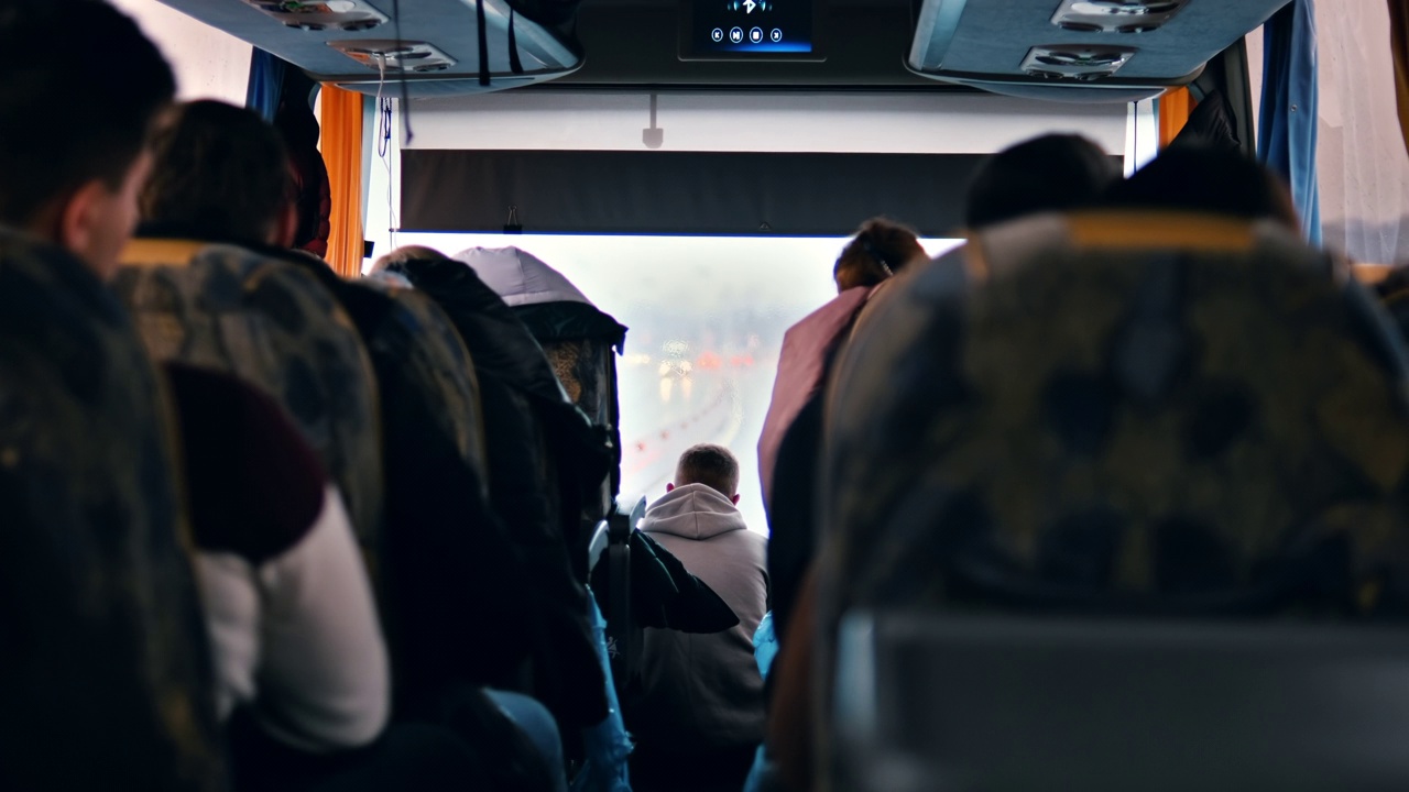 巴士内部的视图，多个坐着的人，道路可以通过窗户看到视频下载