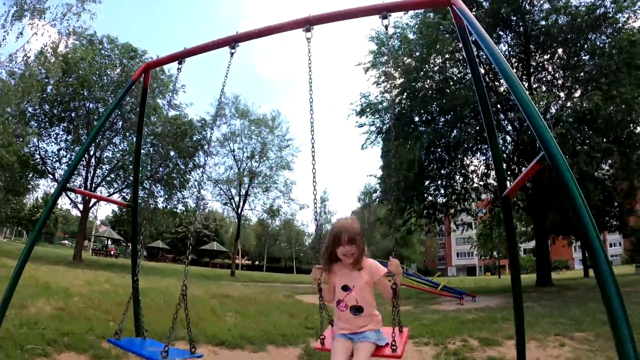 一个小女孩在儿童公园里享受着阳光明媚的一天视频素材
