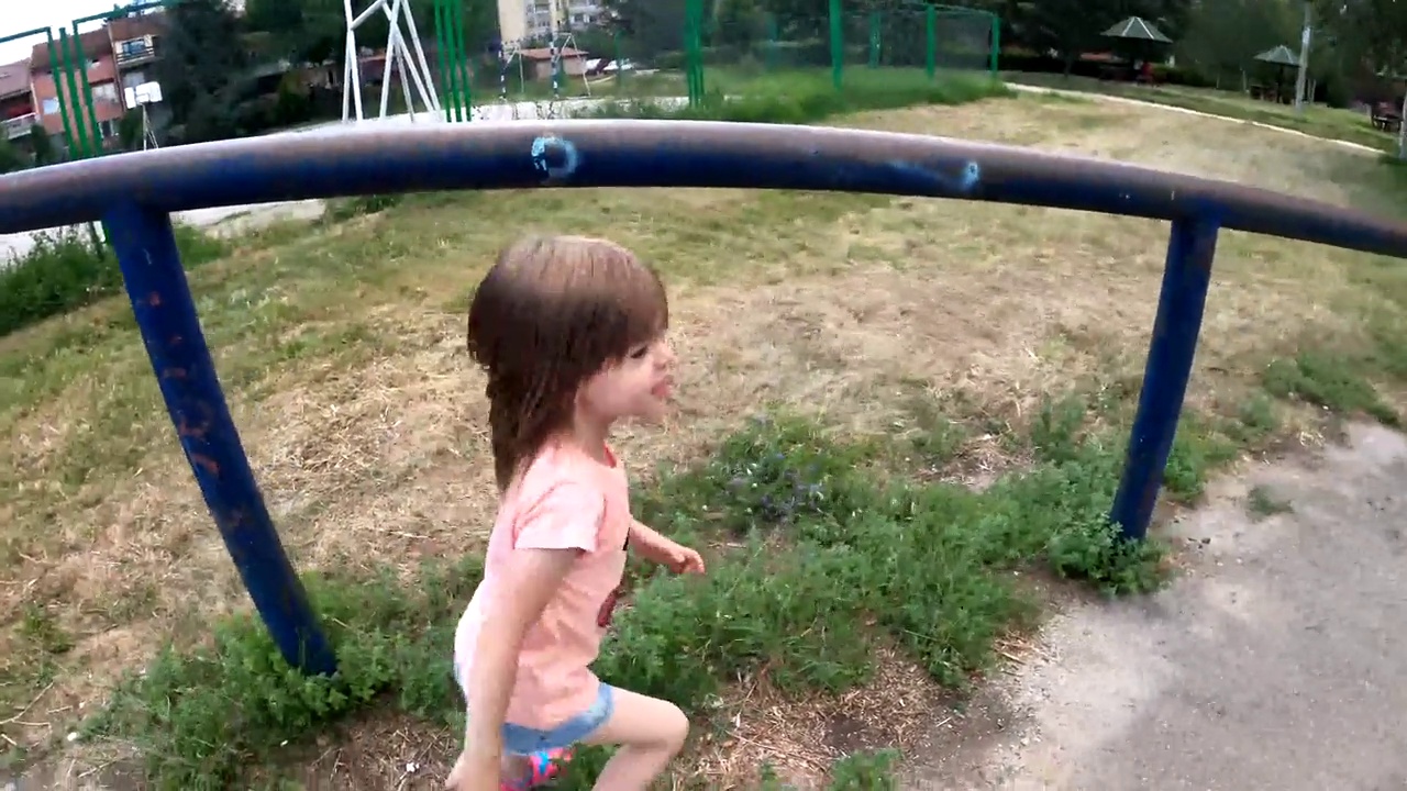 一个小女孩在儿童公园里享受着阳光明媚的一天视频素材