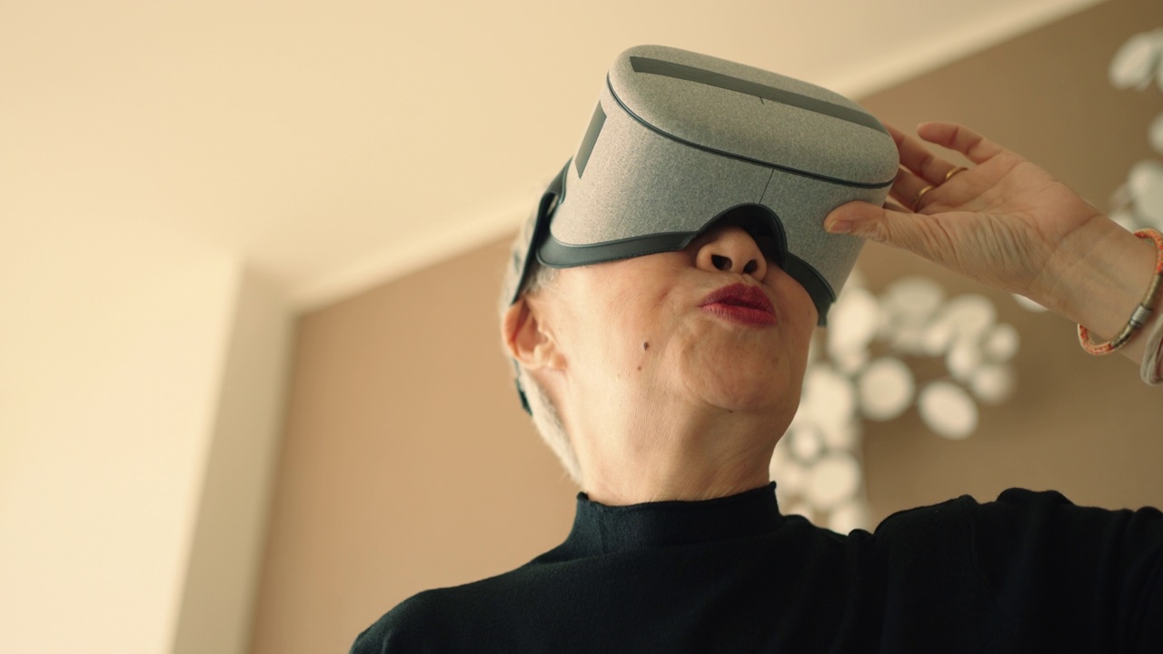 老年女性戴着虚拟现实眼镜玩虚拟游戏视频素材