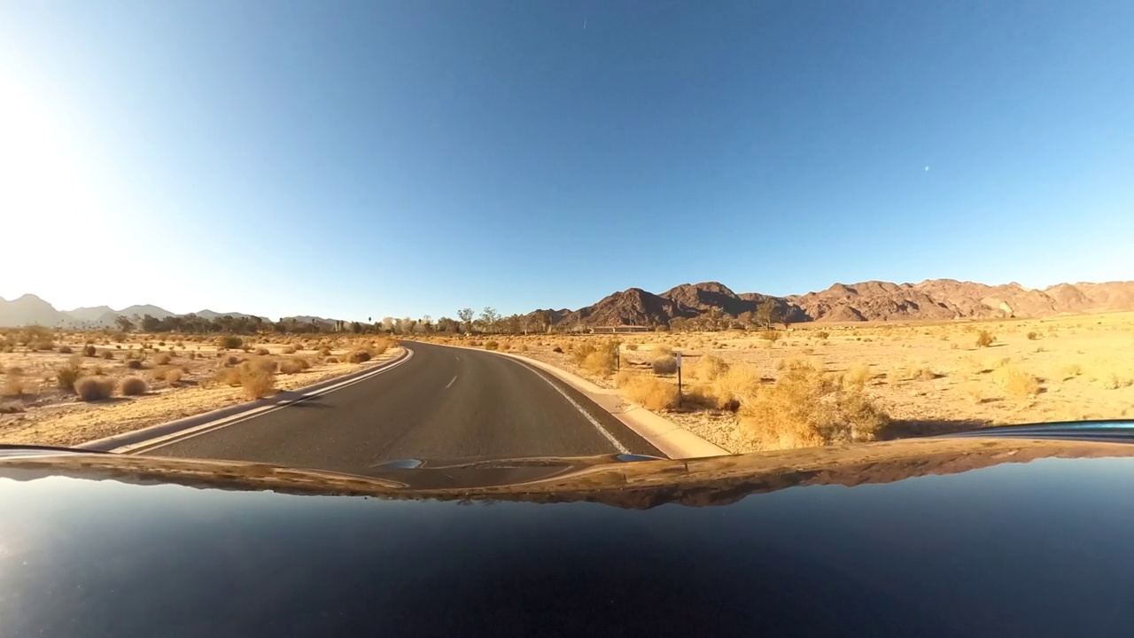 驾车离开湖泊，登上孤立的沙漠公路全景(360)视频下载