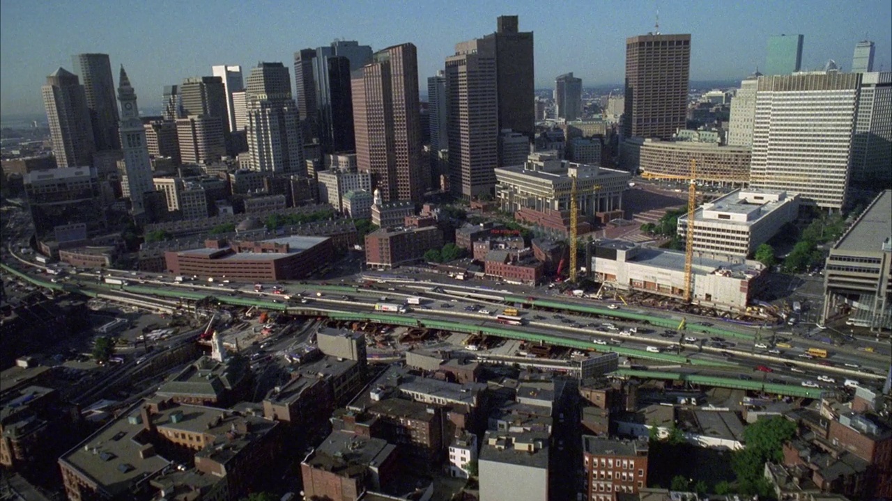 在港口或海湾上空飞向波士顿的天际线。摩天大楼和高层办公或公寓建筑。在市中心。鸟瞰城市。波士顿公共或公园。查尔斯河。视频下载