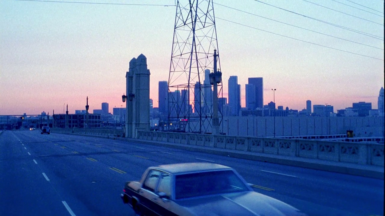 广角驾驶pov从移动的汽车在高速公路或高速公路在洛杉矶。洛杉矶的天际线或黄昏时分的市中心。汽车在街上行驶。可能是黎明。视频下载