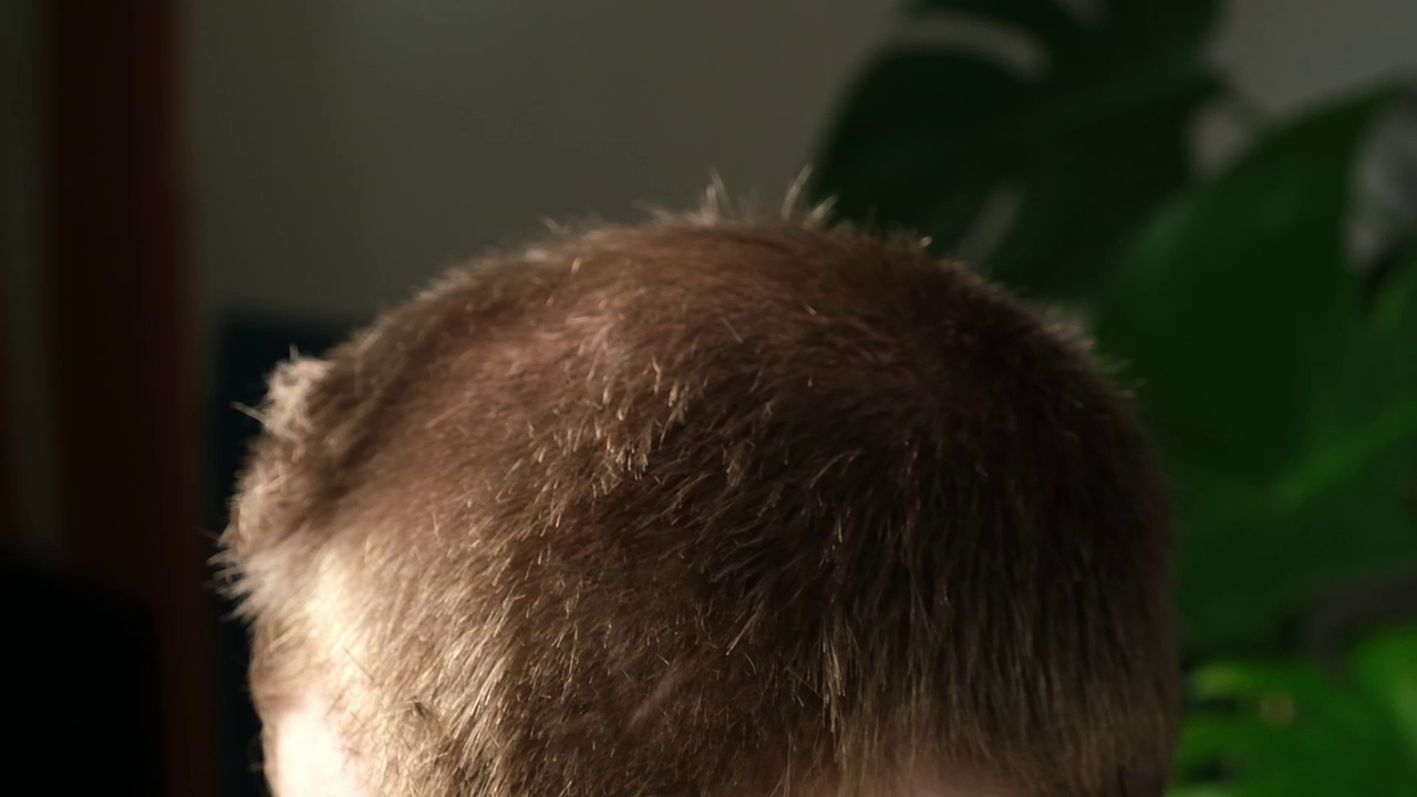 一个男人正在家里用电动剪子理发。家里的发型。省下理发师的钱。视频素材