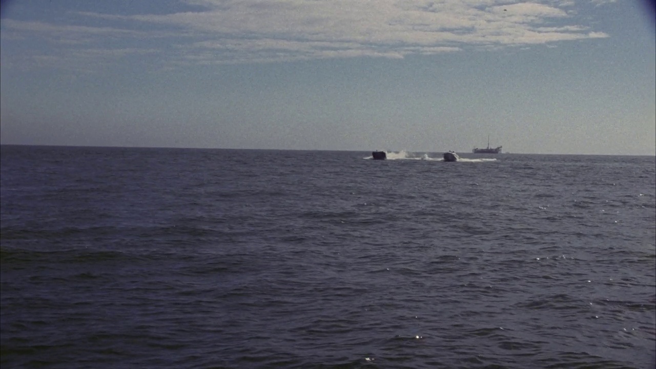 两艘快艇或摩托艇在海洋、湖泊、海湾或港口比赛的广角。蓝天白云。bg的货船和钻井平台。船离开后。视频素材