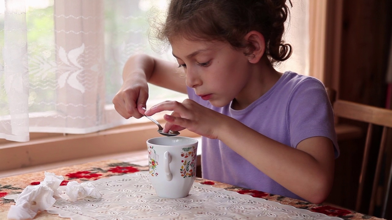 一个孩子试图抓住一杯茶里的柠檬籽视频下载