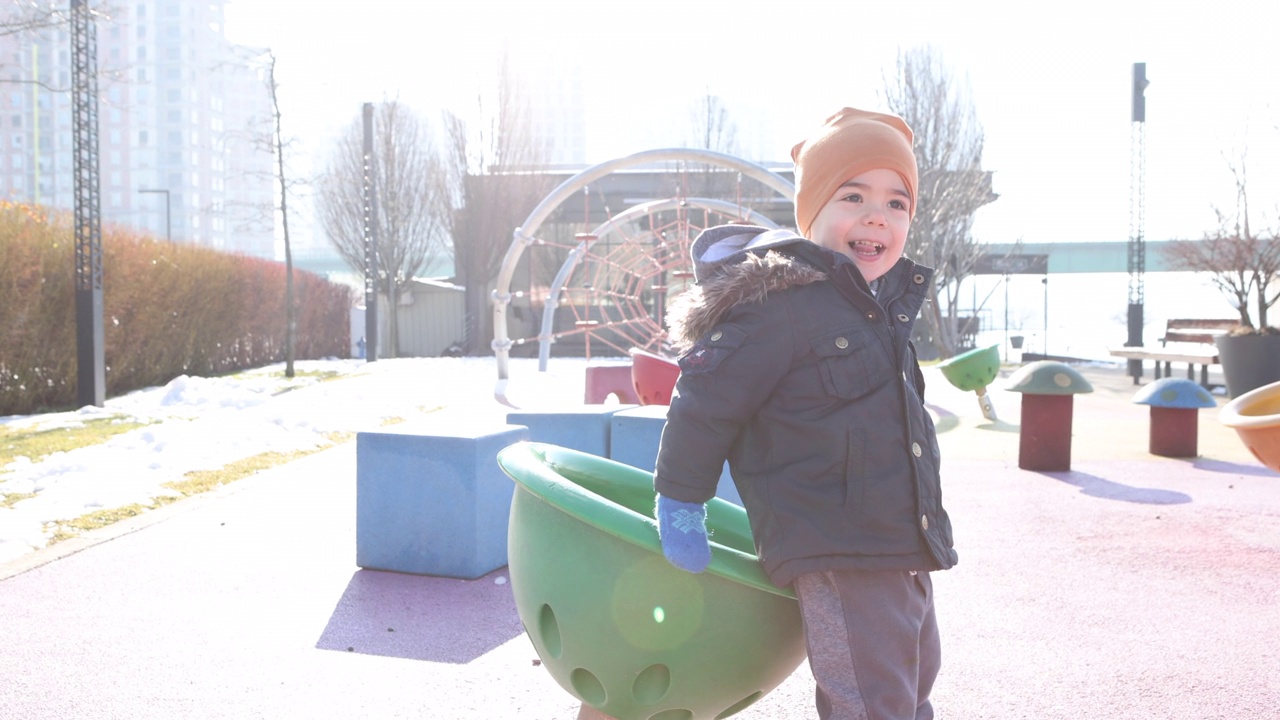 一个小男孩在儿童公园里玩耍视频素材