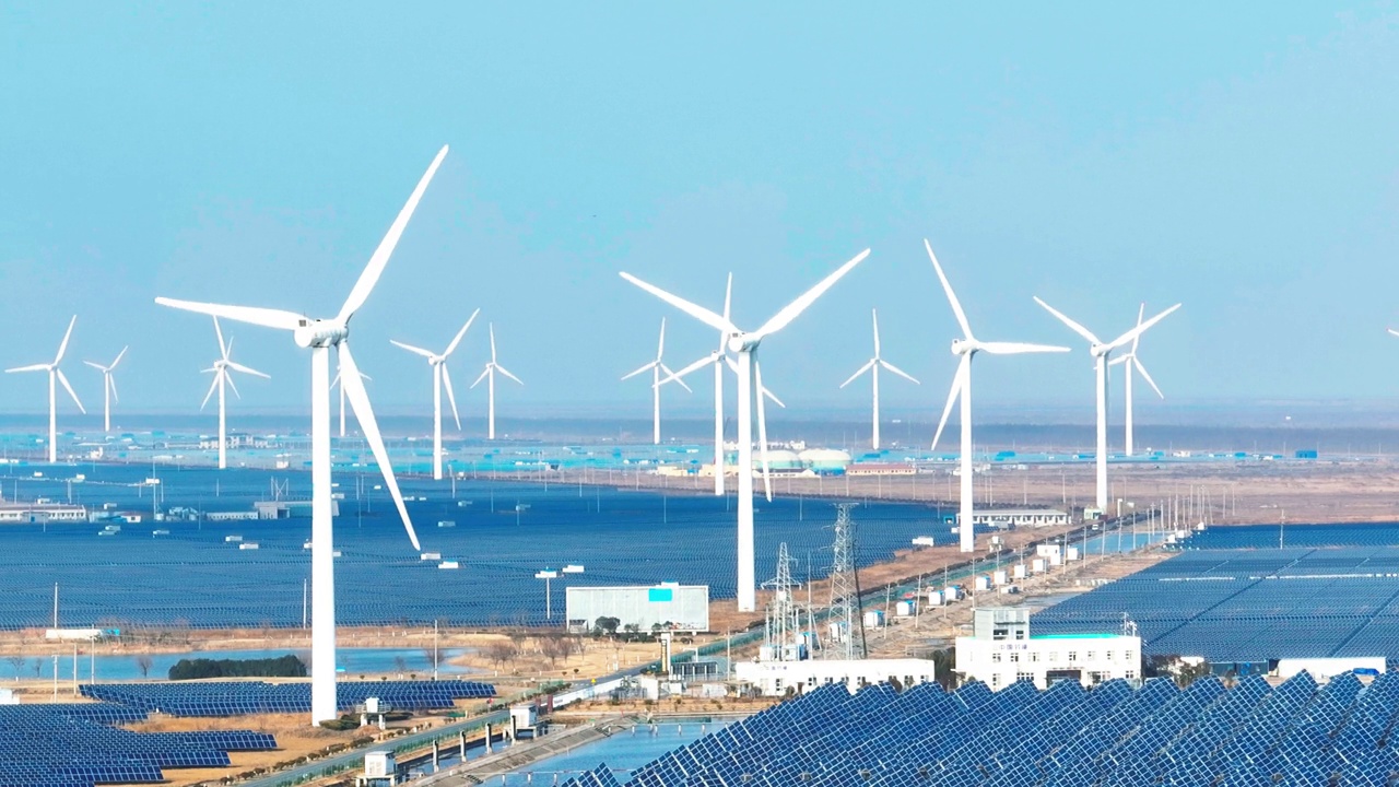 在沿海平原地区，有大面积的太阳能发电站，大型风力涡轮机正在运行。中国江苏省盐城市视频下载