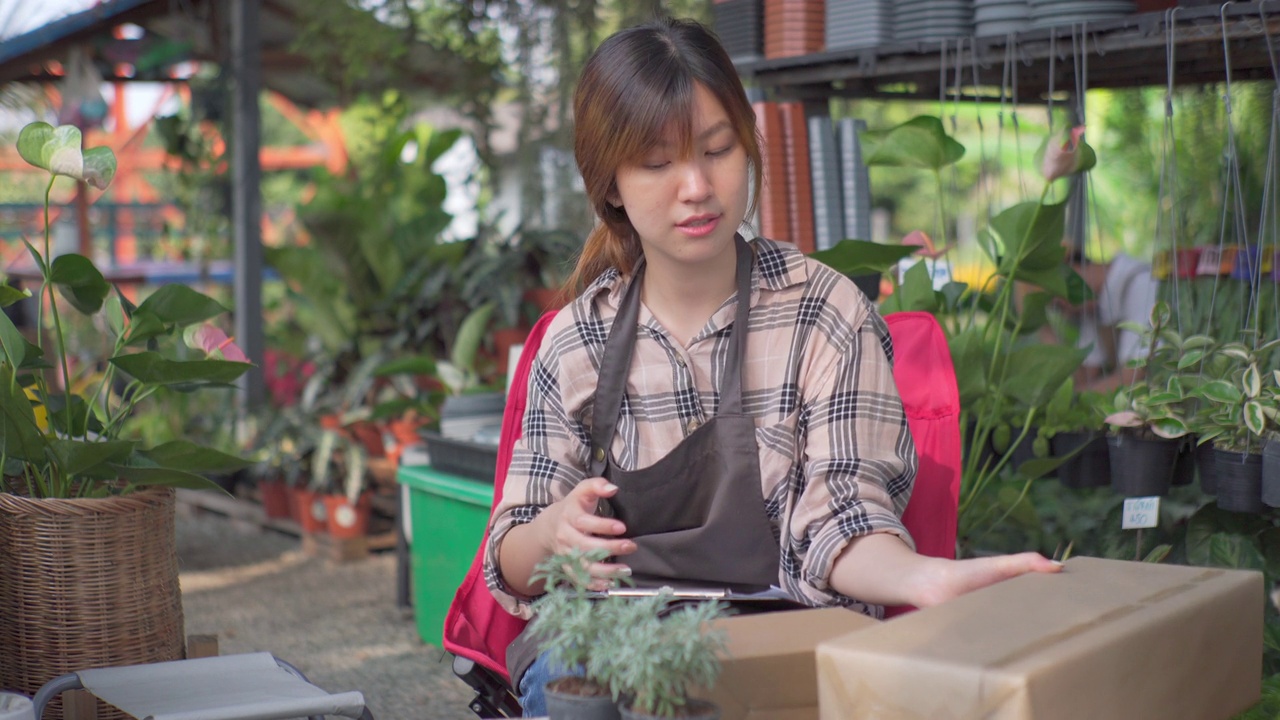 一名女园丁在社交媒体上通过他的商店直播销售植物。视频下载