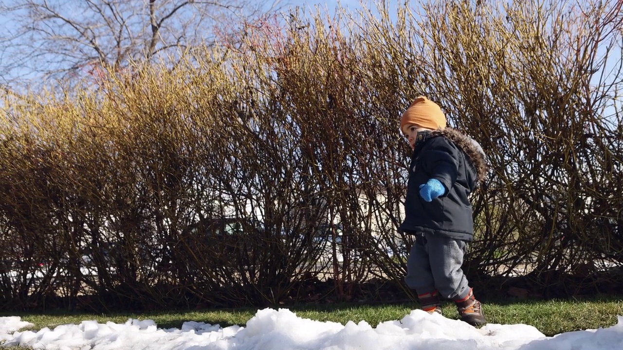 小男孩在公园里玩，扔雪视频素材