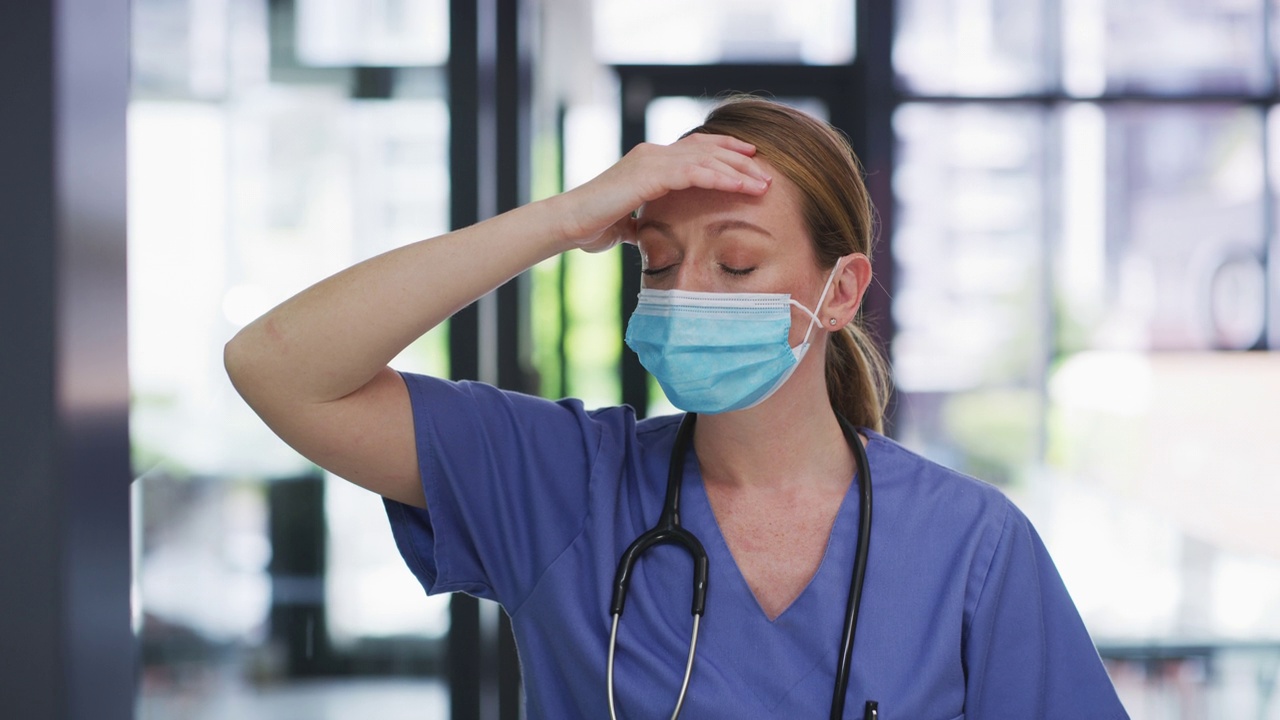 一段4k视频，一名年轻的护士独自站在诊所里，感觉筋疲力尽视频素材