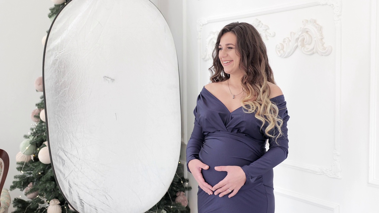 一个孕妇在摄影棚的照片。摄影棚里孕妇的后台照片。视频下载