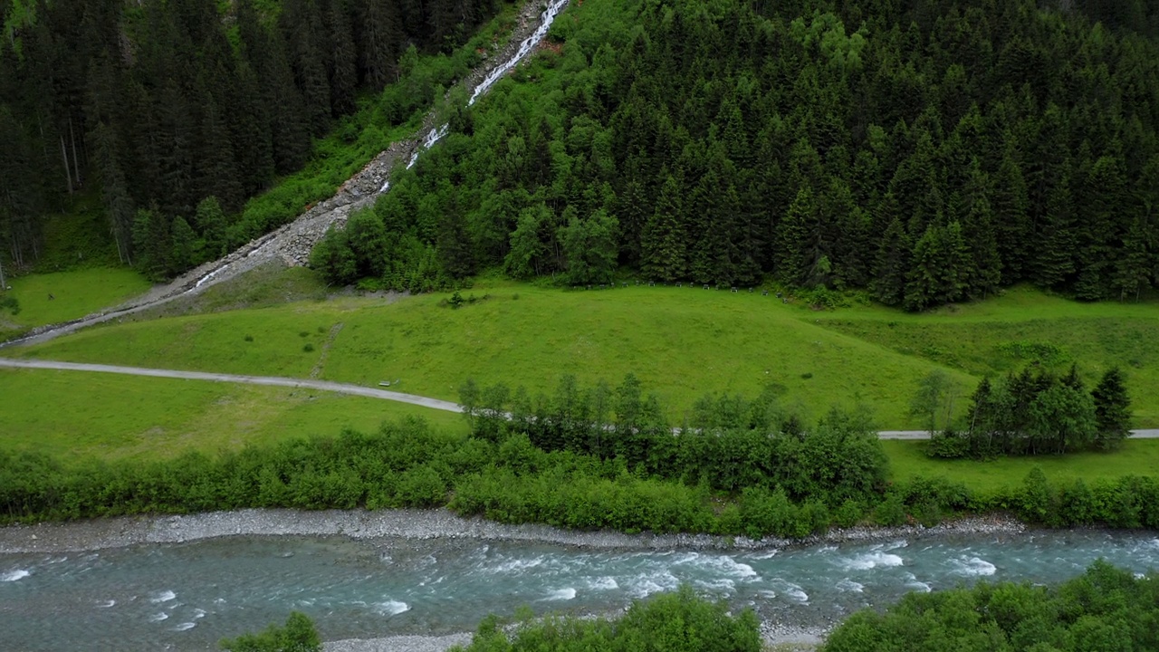 航拍画面显示山谷中有河流、松树林和瀑布。奥地利蒂罗尔州视频素材