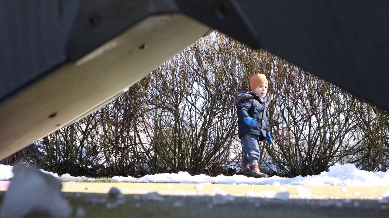 小男孩在公园里玩，扔雪视频素材