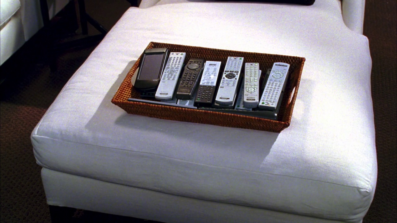 中等角度的一个柳条盒子的遥控器在床上与白色的床单。卧室。远程控制。视频下载