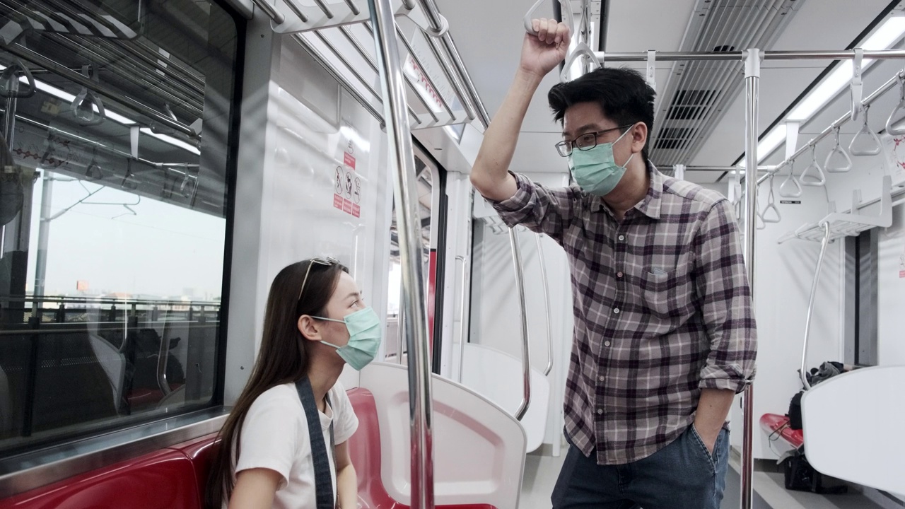 亚洲人戴着口罩乘客在空火车上，乘坐城市轨道交通出行。视频素材
