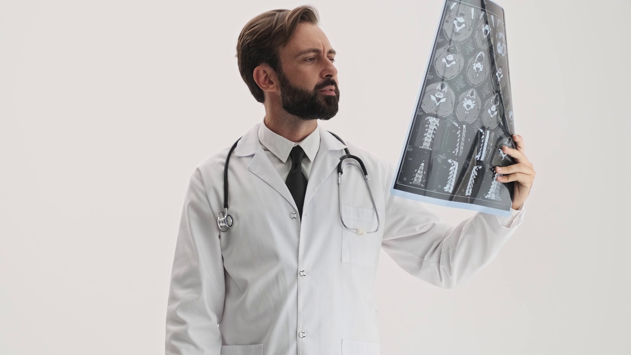 严肃的男医生带着听诊器注视着x线影像视频下载