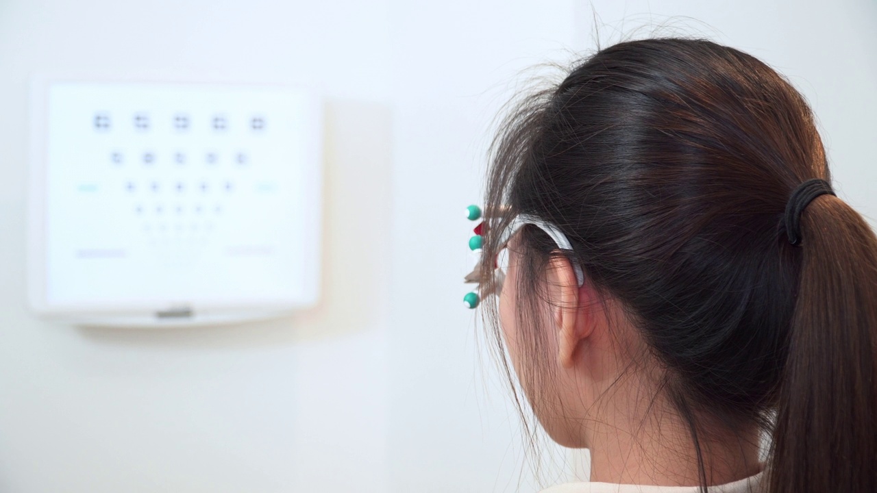 近景，后视图:亚洲年轻女性戴着光学试架测试阅读视力表，斯奈伦图，准备光学眼镜，向后看视频下载