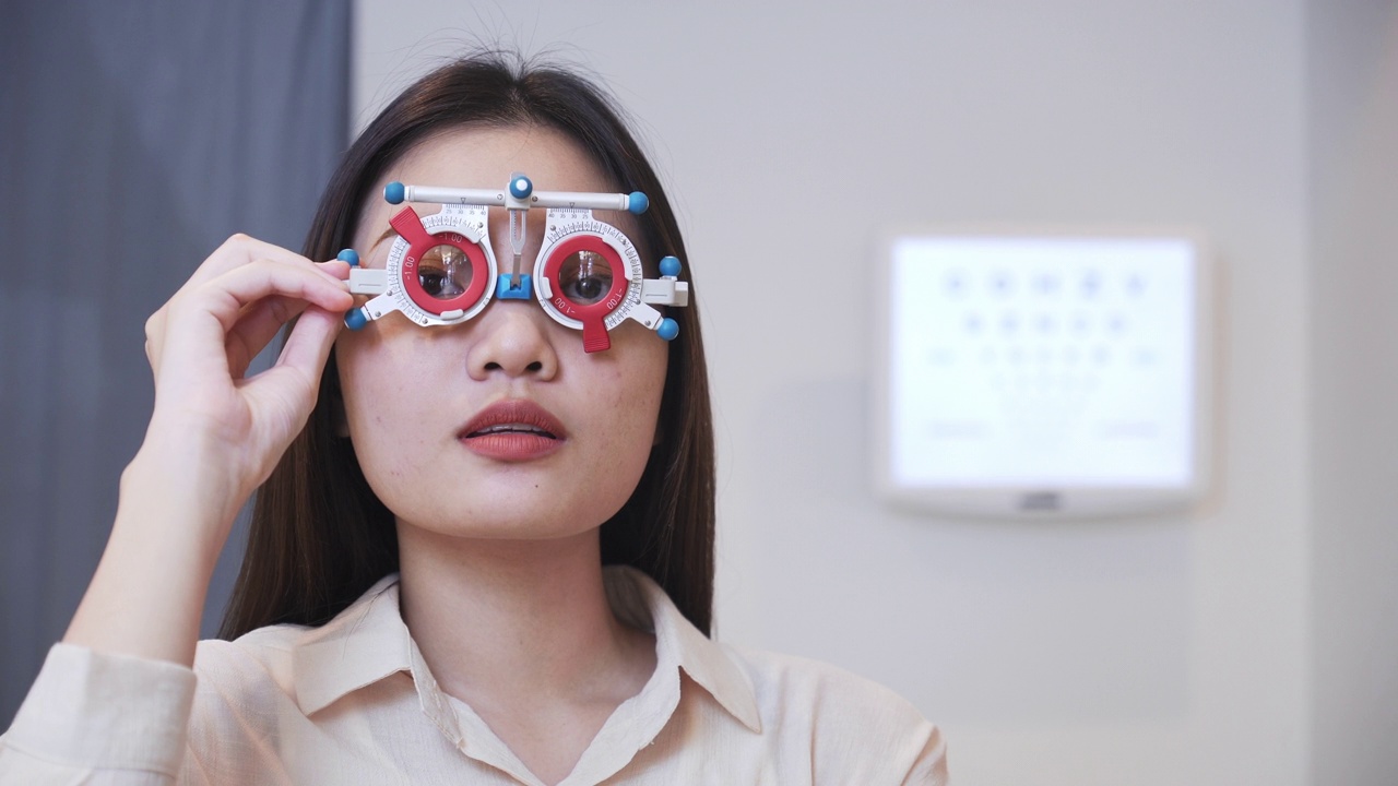 亚洲年轻女子正在调整距离测试框架，测试自己的视力，阅读视力表，Snellen图表，准备戴眼镜，希望有更好的视力视频下载