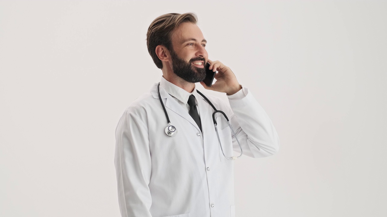 微笑的男医生用听诊器对着智能手机说话视频素材