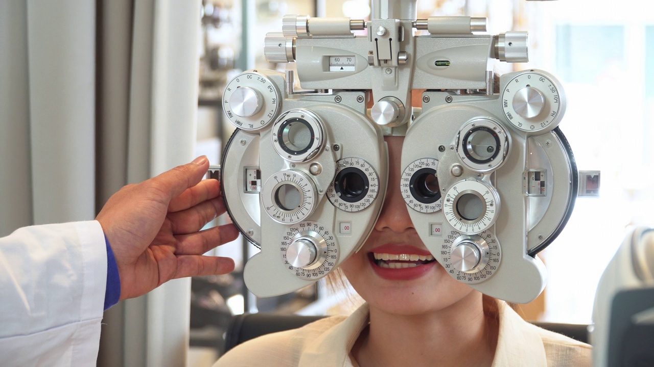 特写:亚洲年轻女子在眼科医生的办公室用专业设备检查她的视力，准备制作光学眼镜视频下载