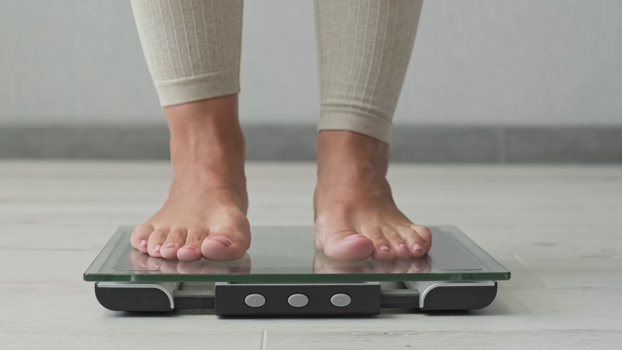 女人测量体重。体重秤。女性检查重量。视频素材