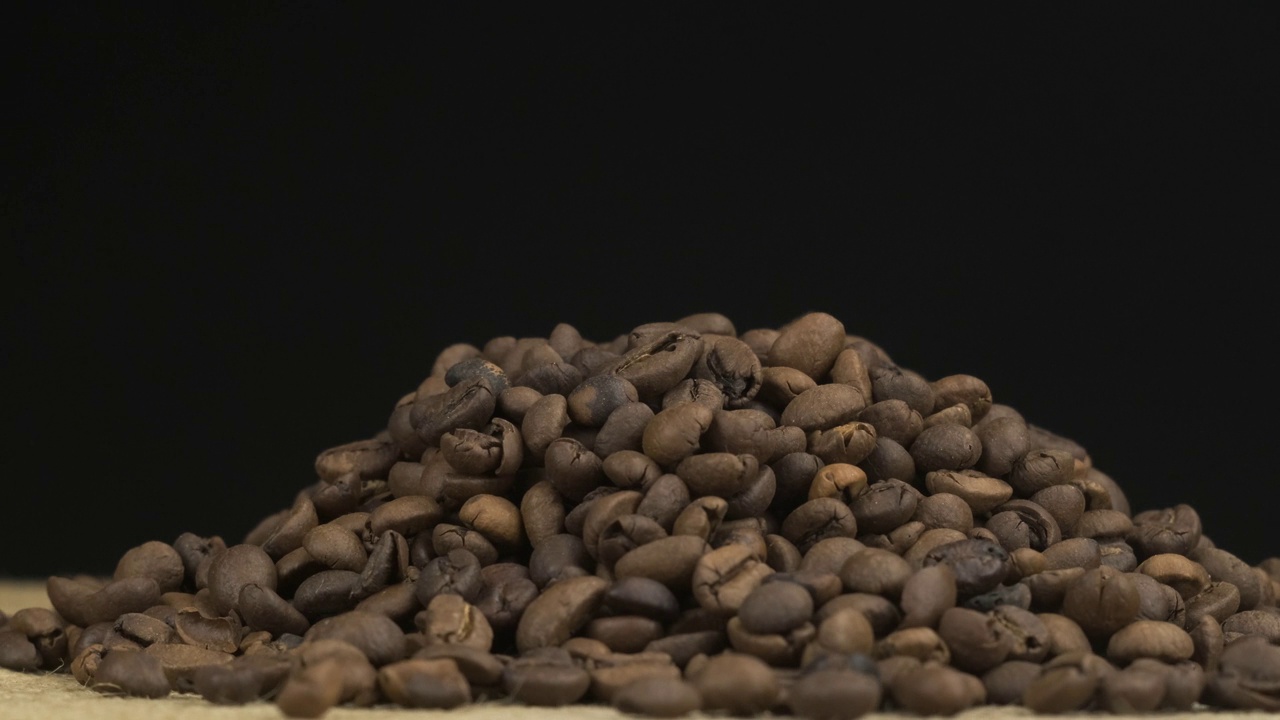 落在一堆咖啡豆上的谷物。旋转谷物堆。孤立的视频下载