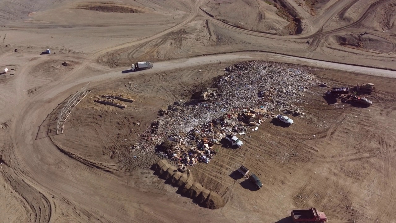 空中拍摄的自卸卡车和顾客在垃圾填埋场排长队倾倒垃圾视频素材