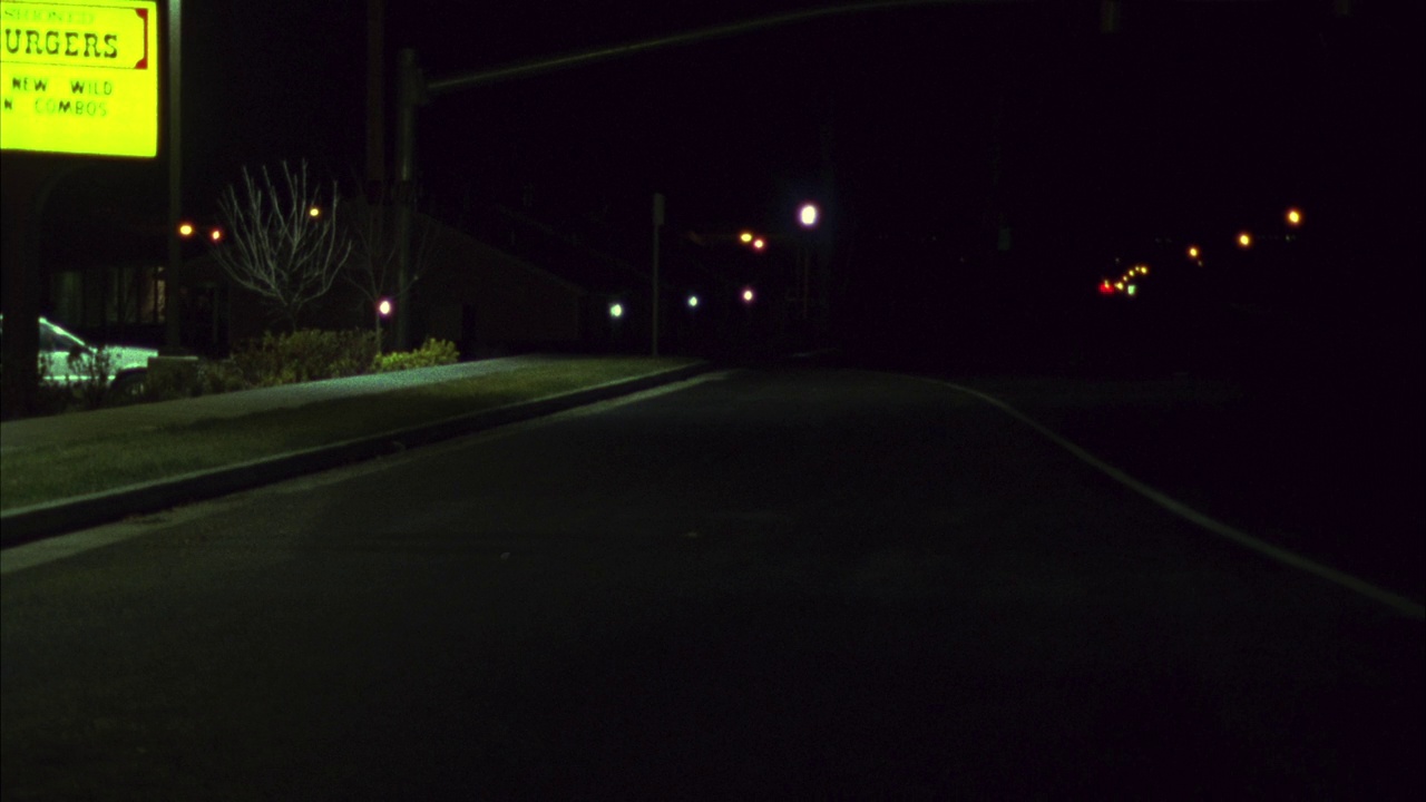 红灯闪烁的空路广角。出租车，然后汽车，轿车与前大灯通过灯向pov。路边快餐店的标志。视频素材
