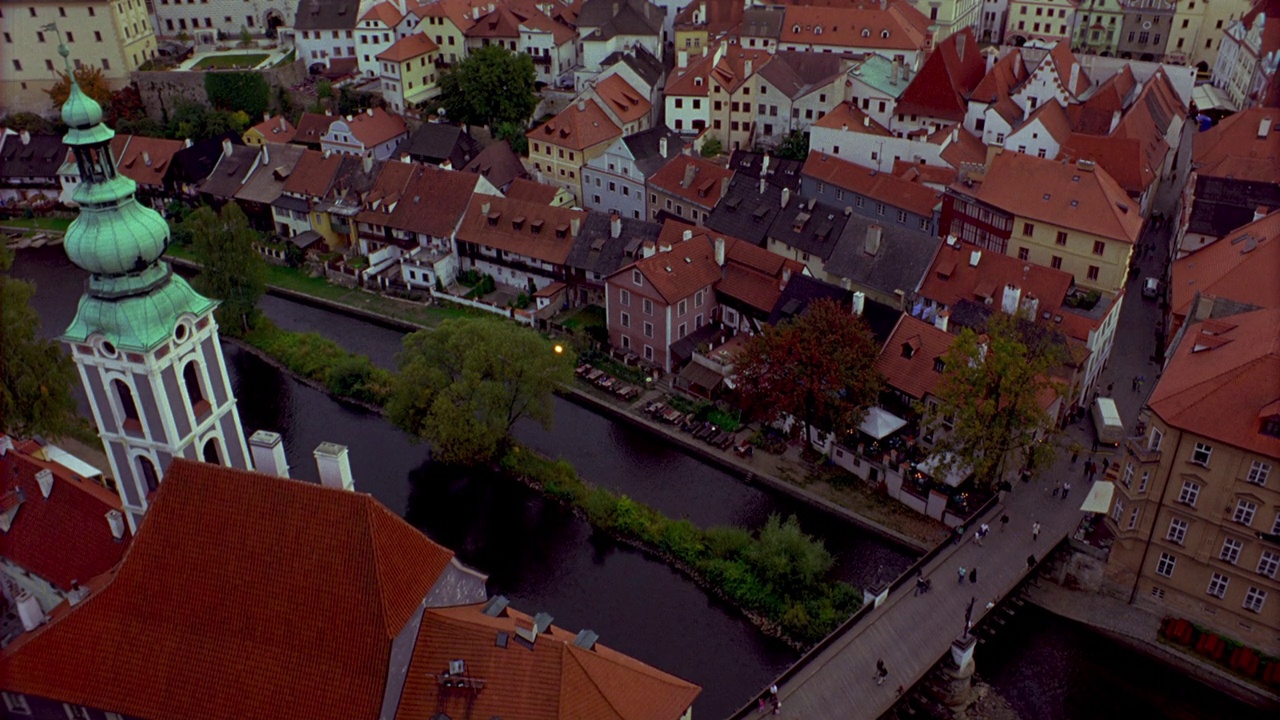 从高处俯瞰捷克的一个小镇。切斯基克鲁姆洛夫，捷克共和国。镜头从河上的一座桥上摇摄到城市的天际线或城市景观。可以冒充布拉格。建筑和房屋止于山头。欧洲。视频下载