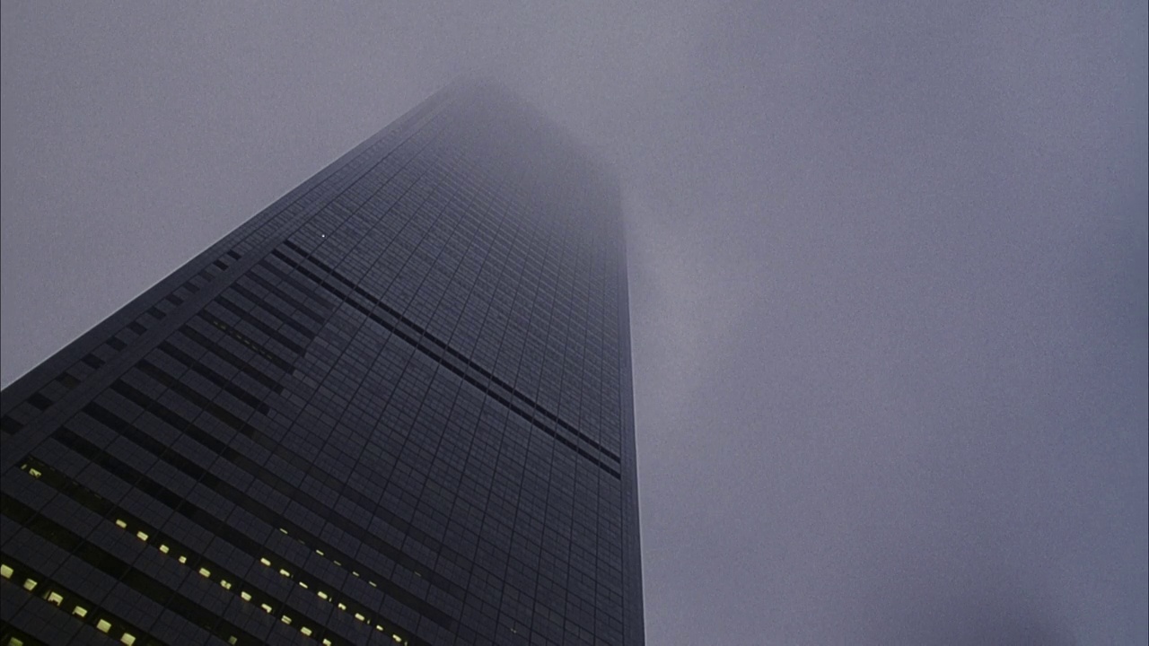 高层办公楼向上的角度。看到雾在楼顶翻滚。摩天大楼。视频下载