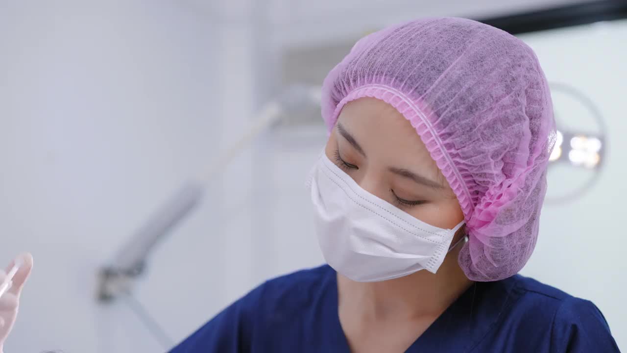 有魅力的年轻亚洲女子正在美容诊所接受面部注射，以恢复青春活力。专家美容师用a型肉毒杆菌毒素填补女性皱纹。抗皱手术、抗衰老、面部治疗、光疗、肉毒杆菌素。视频下载