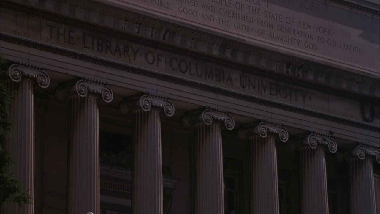 巴特勒图书馆上刻有“哥伦比亚大学图书馆”的标志。离子列。平底锅左边是旗杆上的美国国旗，然后平底锅下放到楼梯的栏杆上。视频下载