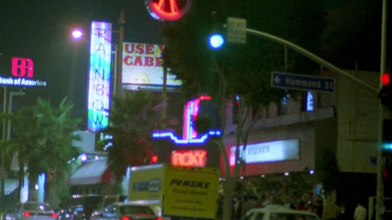 中角的霓虹灯和红绿灯“roxy”酒吧和音乐俱乐部在日落大道。bg中的“彩虹酒吧和烧烤”。汽车驾驶。日落大道。夜总会。视频素材