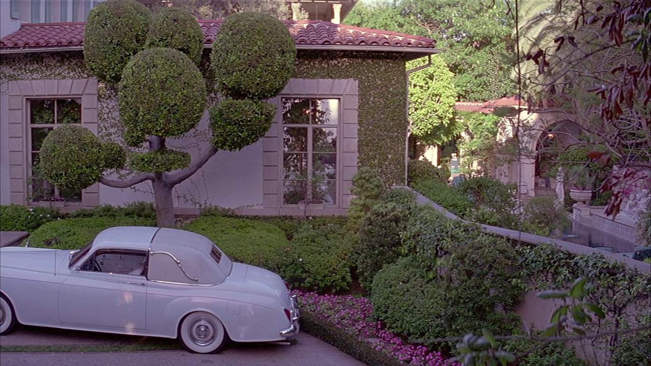 从1960年起，潘离开白色宾利停在车道上的西班牙风格的房子。看到树生长在前面的房子和部分模糊的视野。视频下载